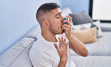 young-hispanic-man-using-inhaler-sitting-sofa-home 1 Houston Wellness & Injury Clinic|Conditions
